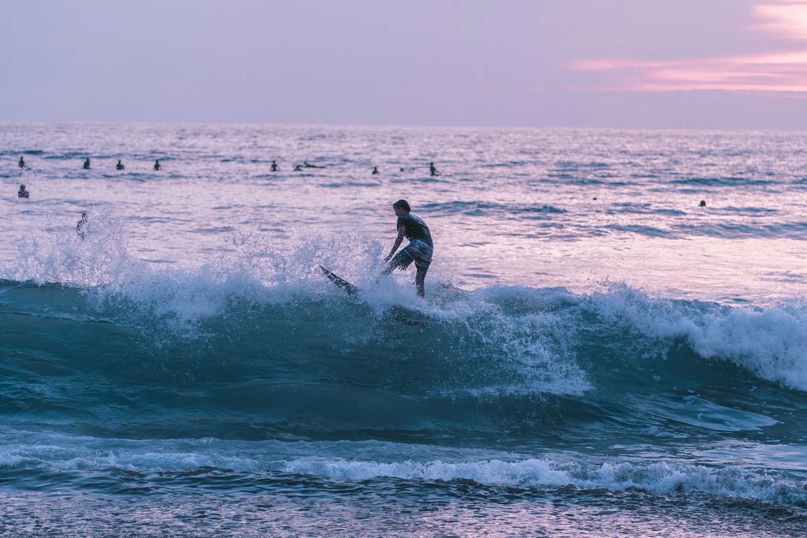 Surfer riding a Bali wave in late light