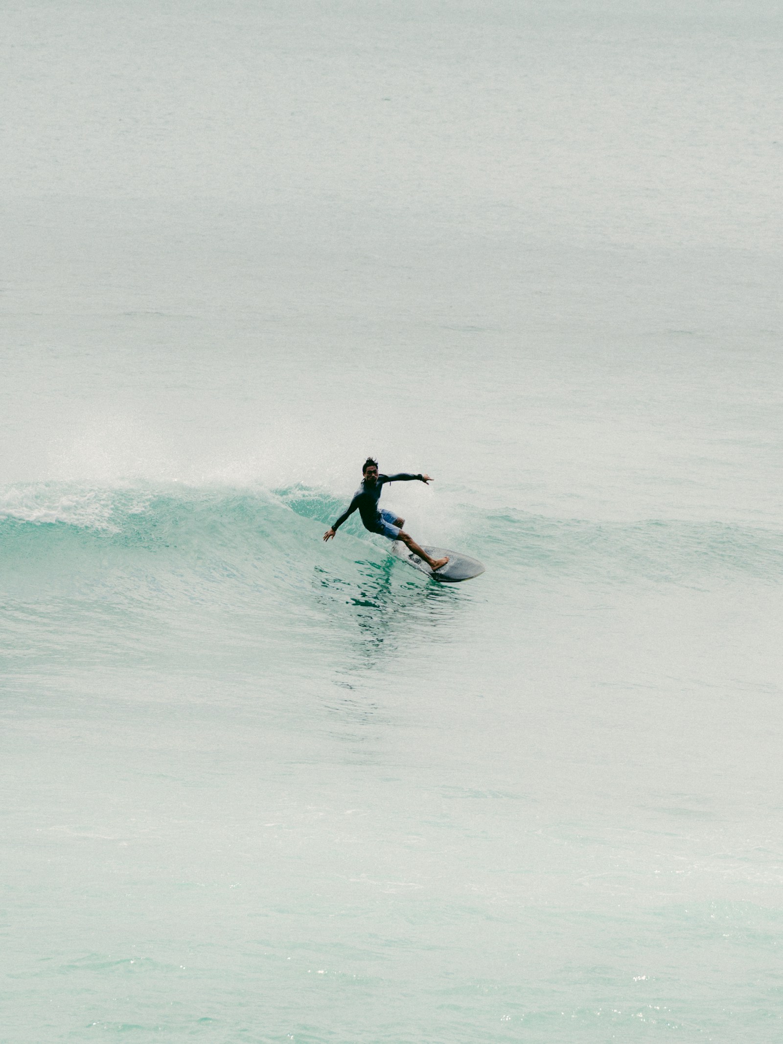 Surfer riding a clean green wave in Indonesia