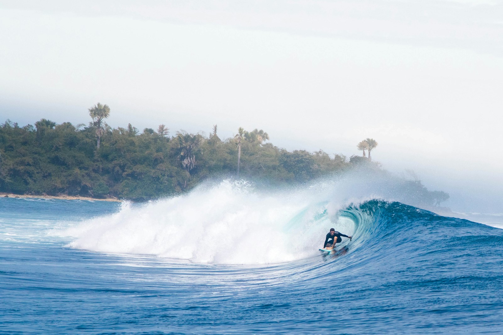 Surfer riding a lined-up Indonesian reef wave