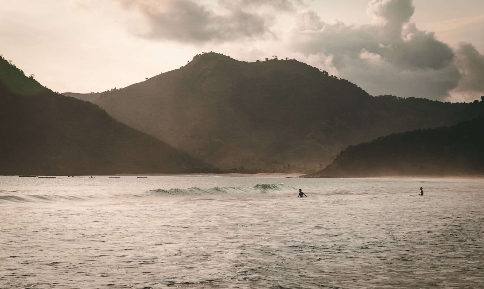 Surfers moving through an Indonesian lineup at sunset
