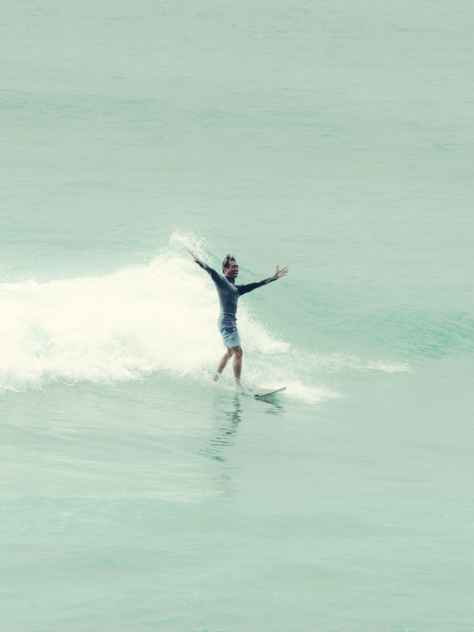 Surfer trimming across a clean Indonesian wave