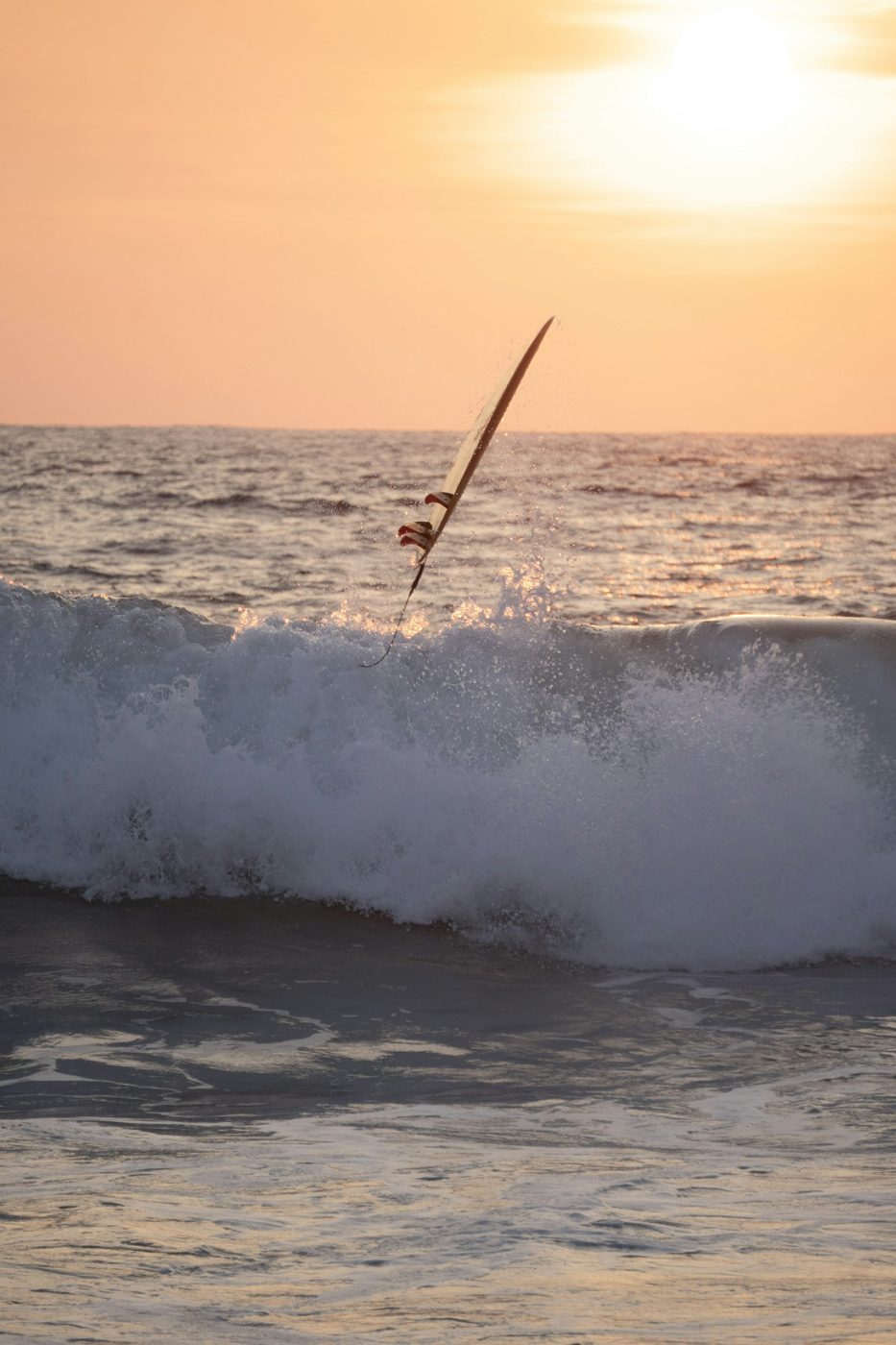 Regional photograph — a surfer and breaking wave at Puerto Escondido, Oaxaca, Mexico.