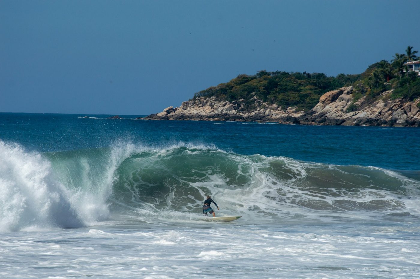 Regional photograph — a surfer on a breaking wave at Playa Zicatela, Oaxaca, Mexico.