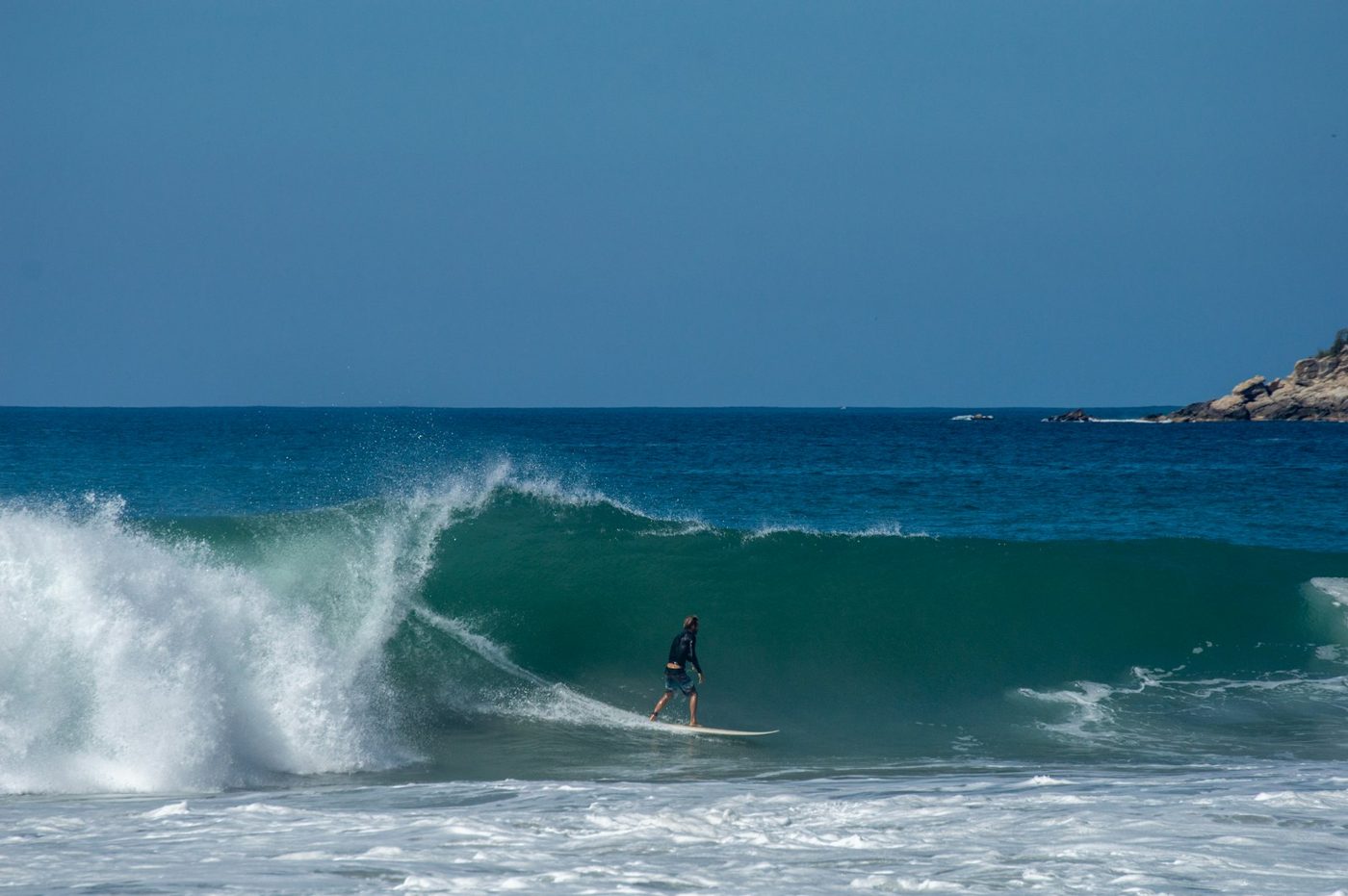 Regional photograph — a surfer on a breaking wave at Playa Zicatela, Oaxaca, Mexico.